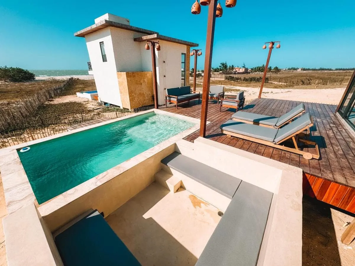 Piscina privativa vista do andar superior, com espreguiçadeiras no deck e as outras casas ao fundo